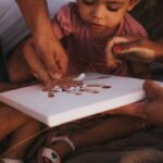 A young child painting with parents in Quixeramobim, Brazil, durin